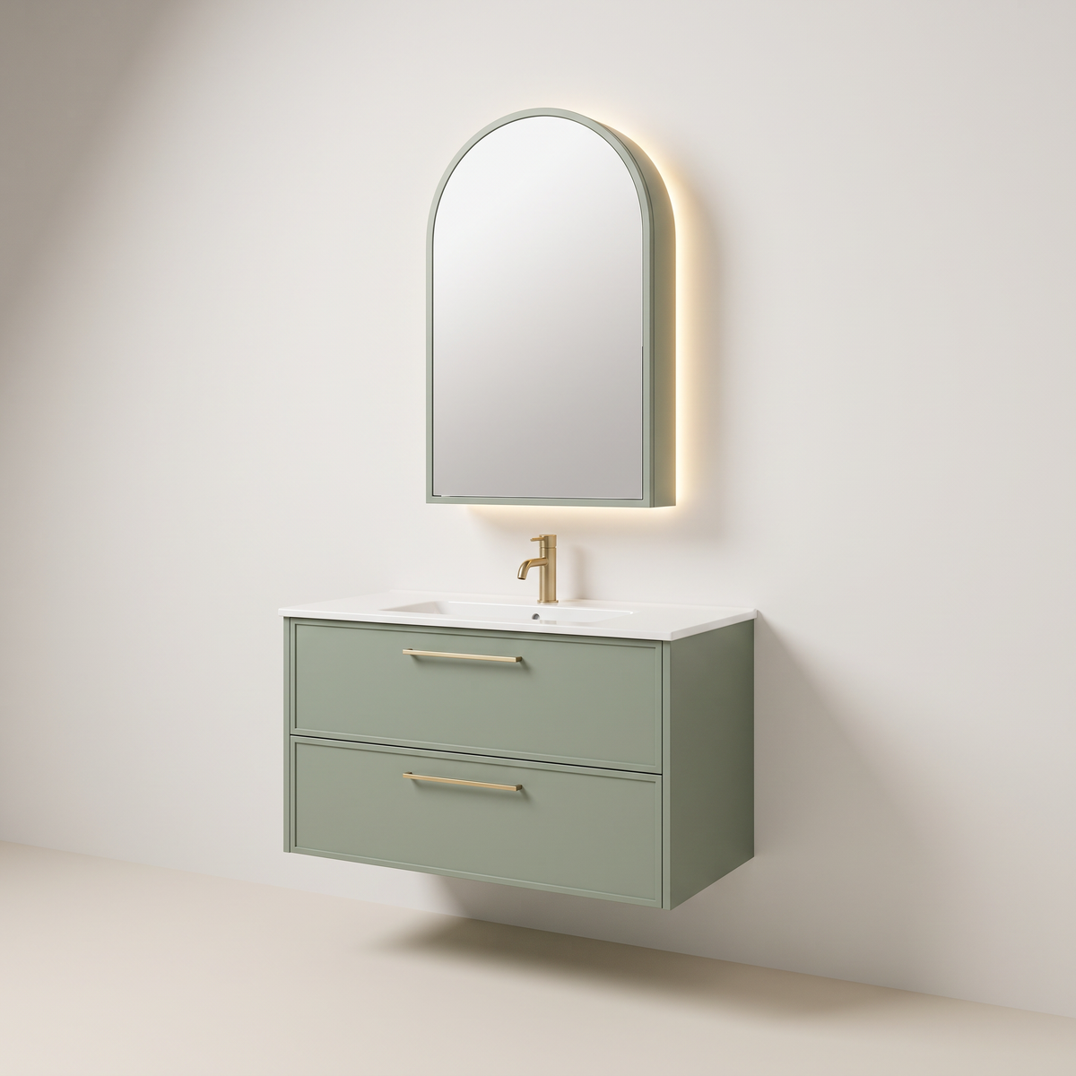 Arch Mirror Vanity, wall-hung sage-green vanity with two drawers, brass bar pulls, white integrated basin top and arched backlit mirror cabinet, three-quarter studio view