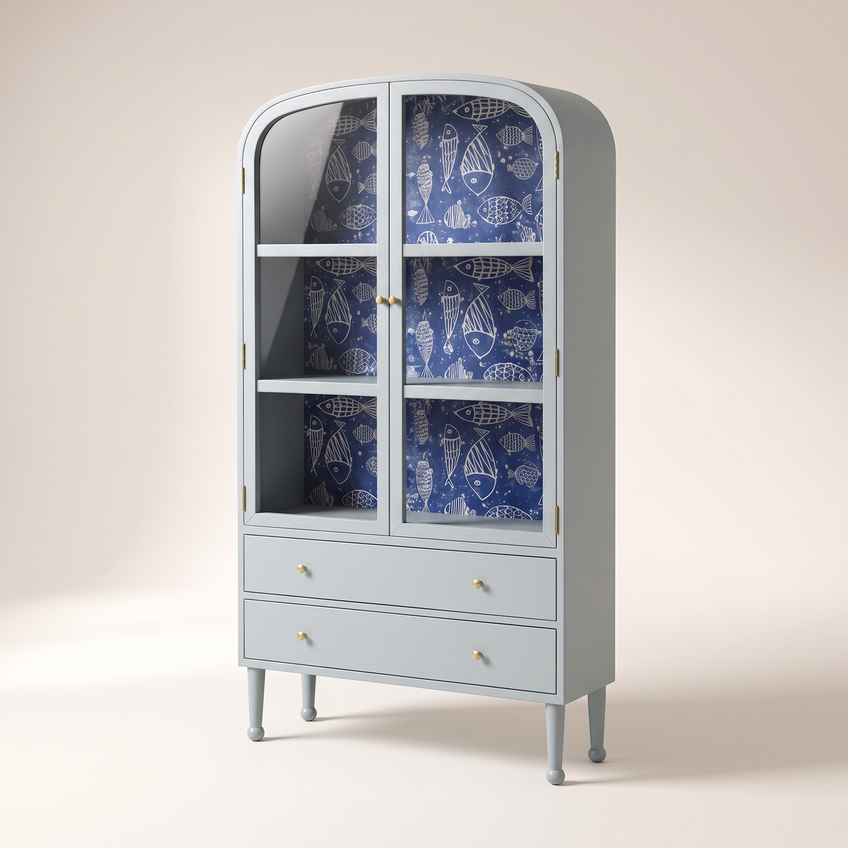 Azure Cove Cabinet in powder blue with glass doors, navy fish-print wallpaper, two drawers and brass knobs, front three-quarter view