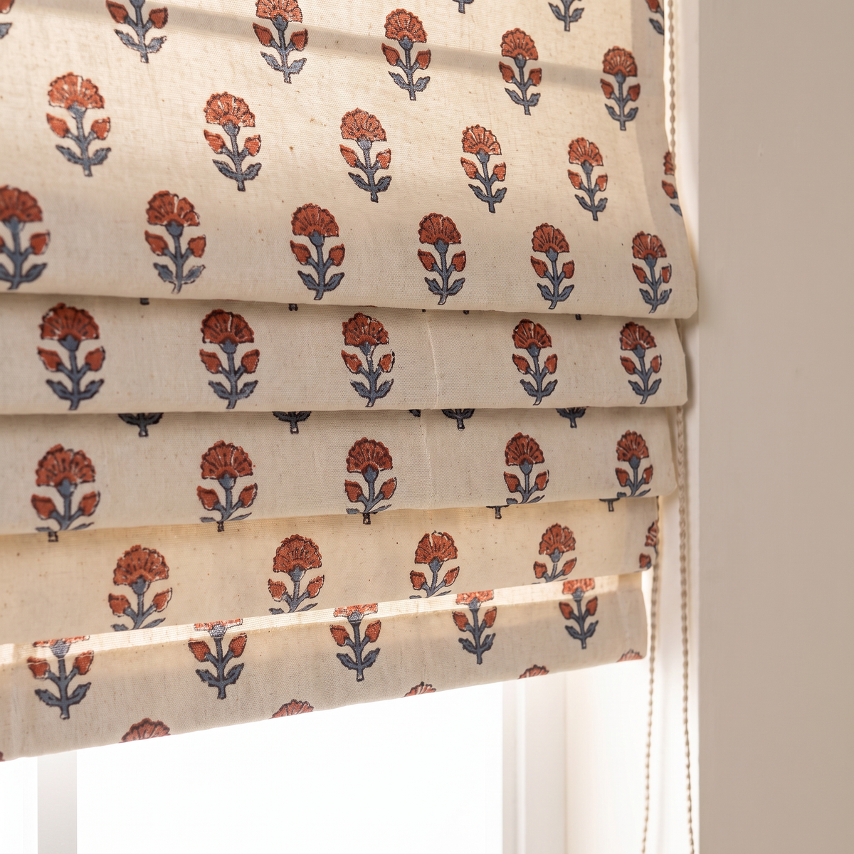 Close-up of Bagh Roman Blind folds showing the hand block-printed rust and indigo buti on ivory cotton