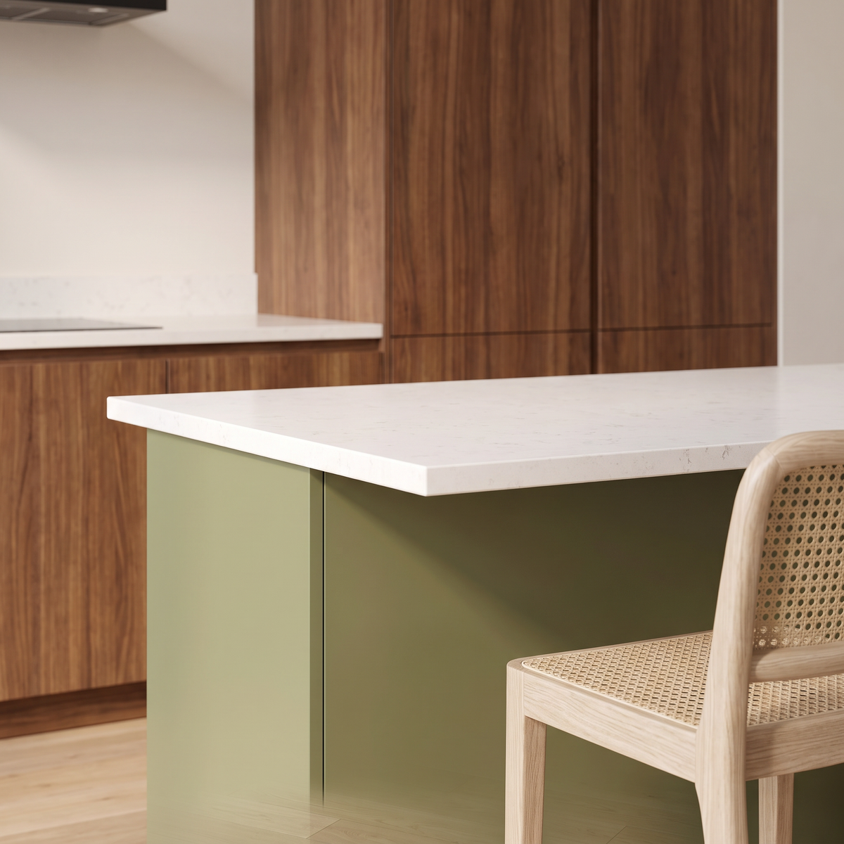 Banyan Island detail of the olive matte island front, thick white quartz edge and cane-seat stool against walnut veneer