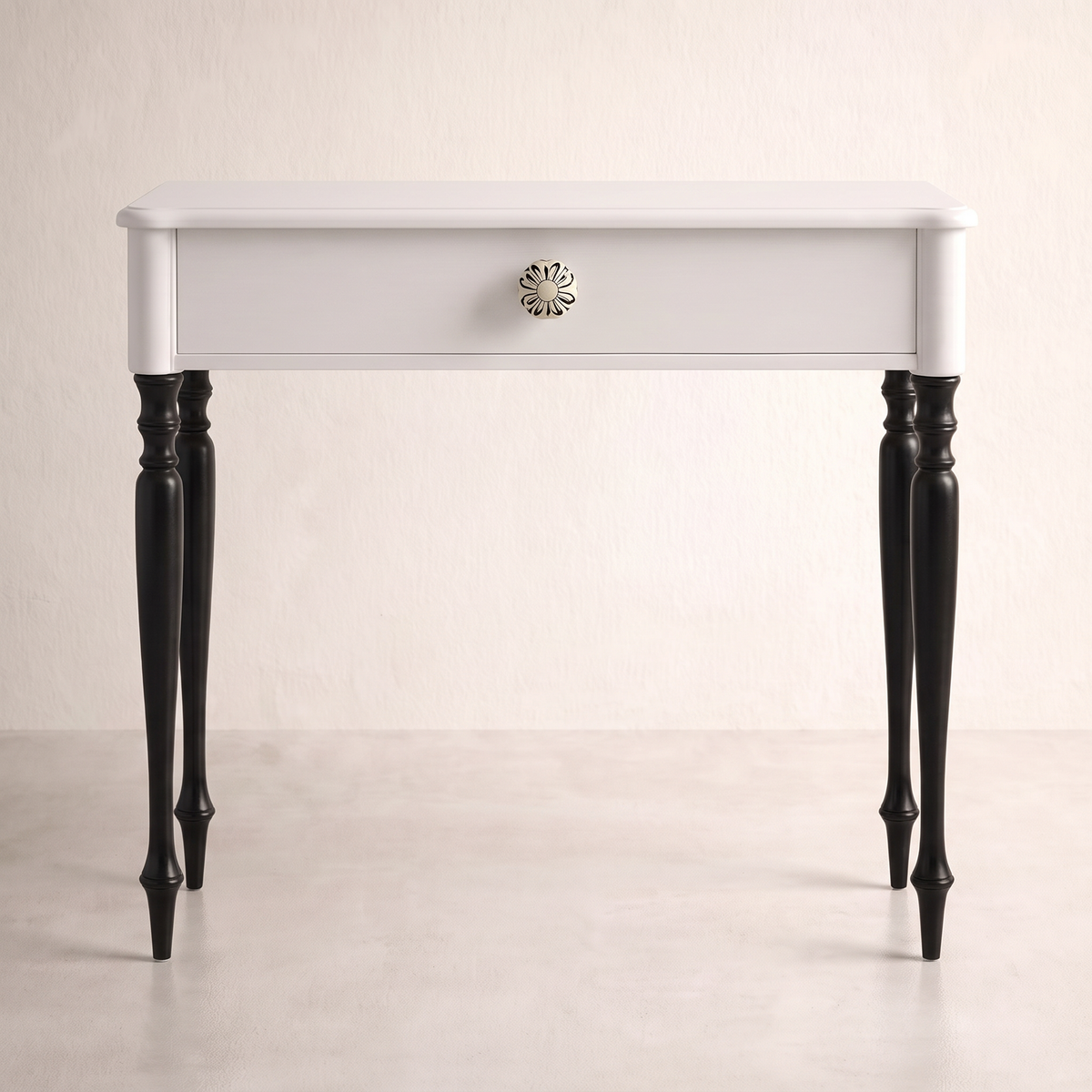 Belle console table in white with one drawer, floral ceramic knob and black turned legs, front view