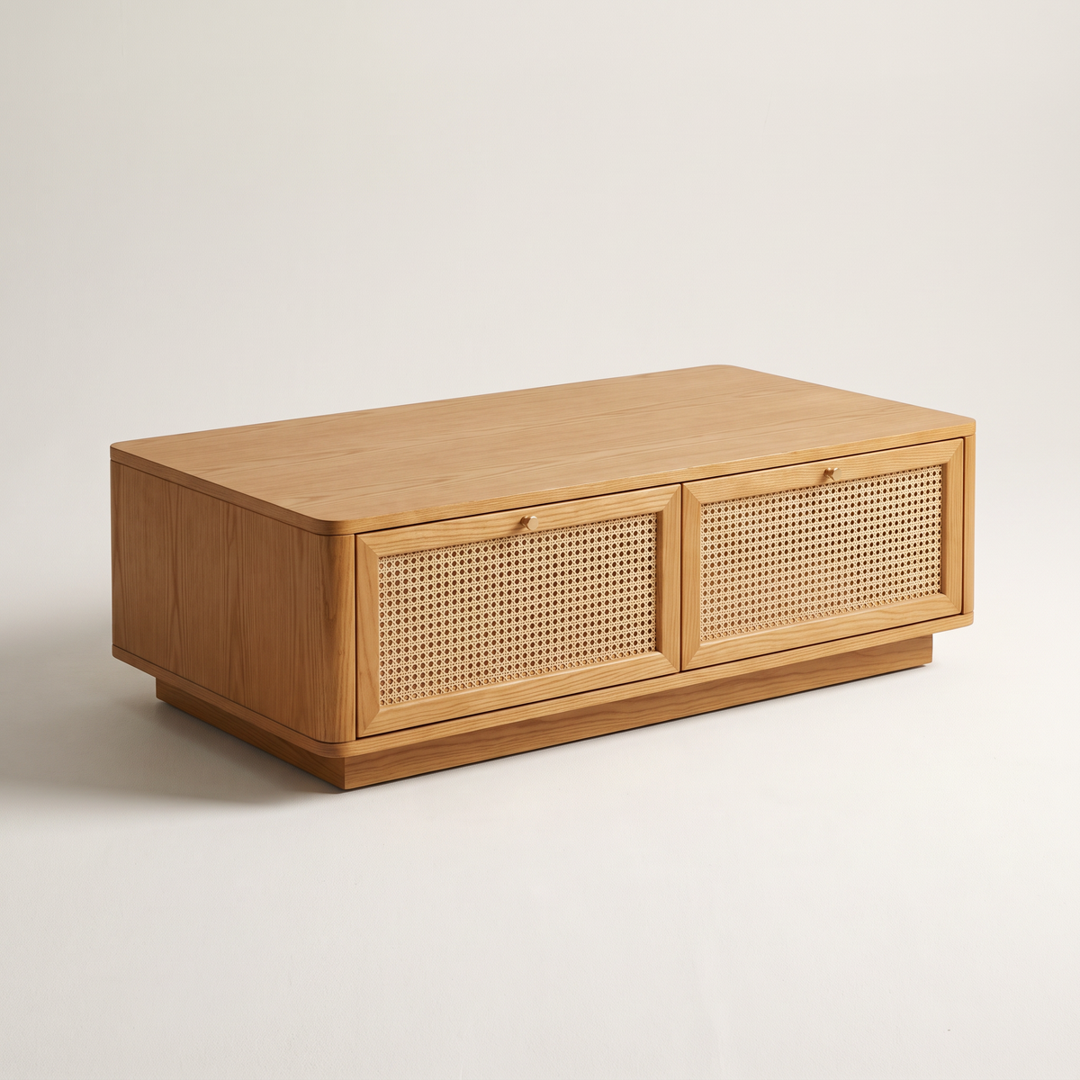 Bento Ash coffee table in honey ash with two woven cane drawer fronts, brass knobs and recessed plinth, front three-quarter view
