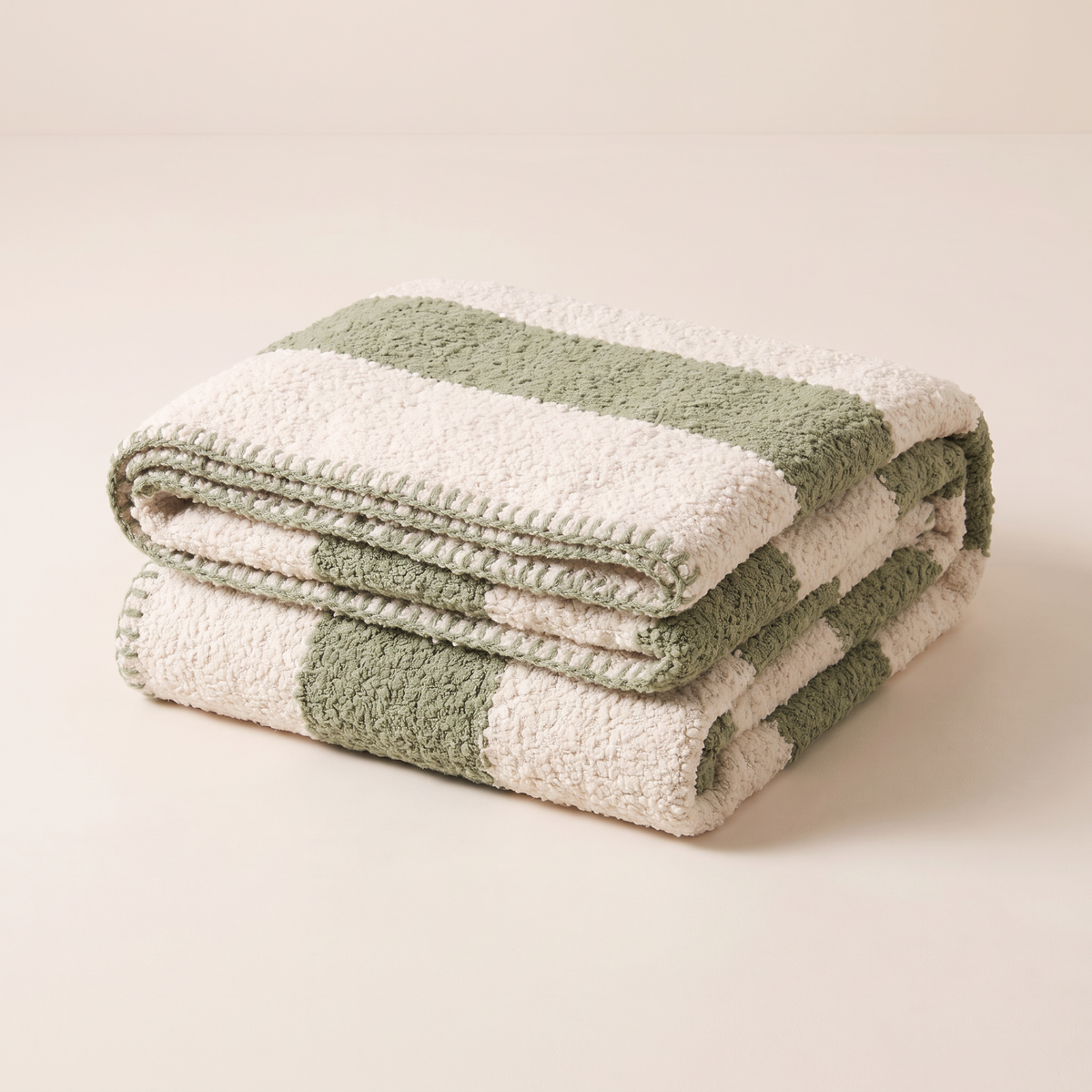 Bouclé Stripe Throw in ivory and sage bands, folded neatly