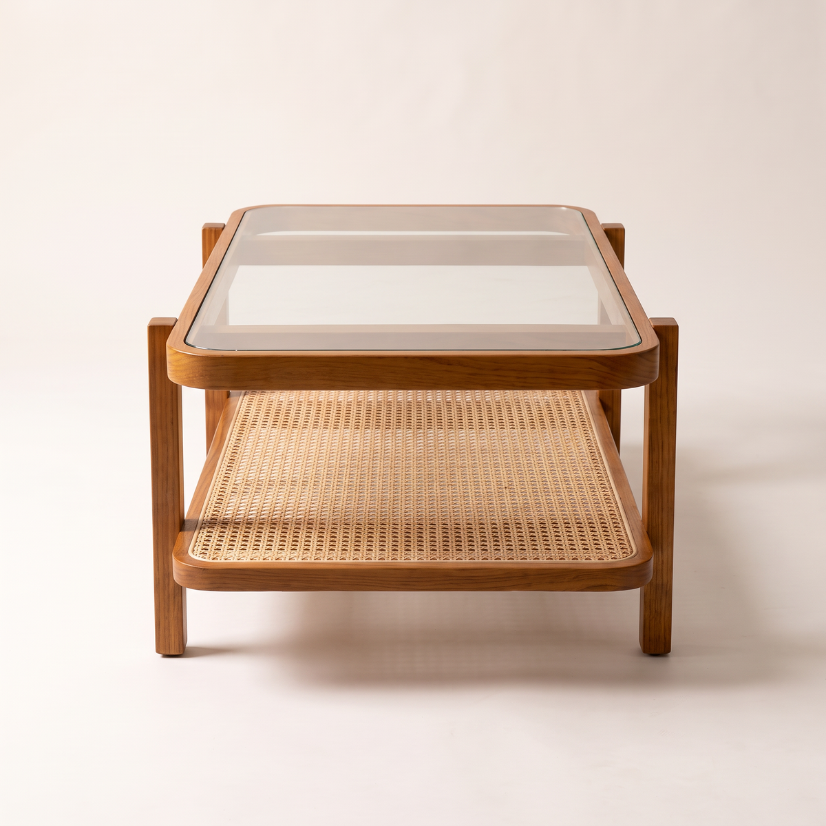 Canehaven coffee table in honey ash wood with clear glass top and woven cane shelf, end view