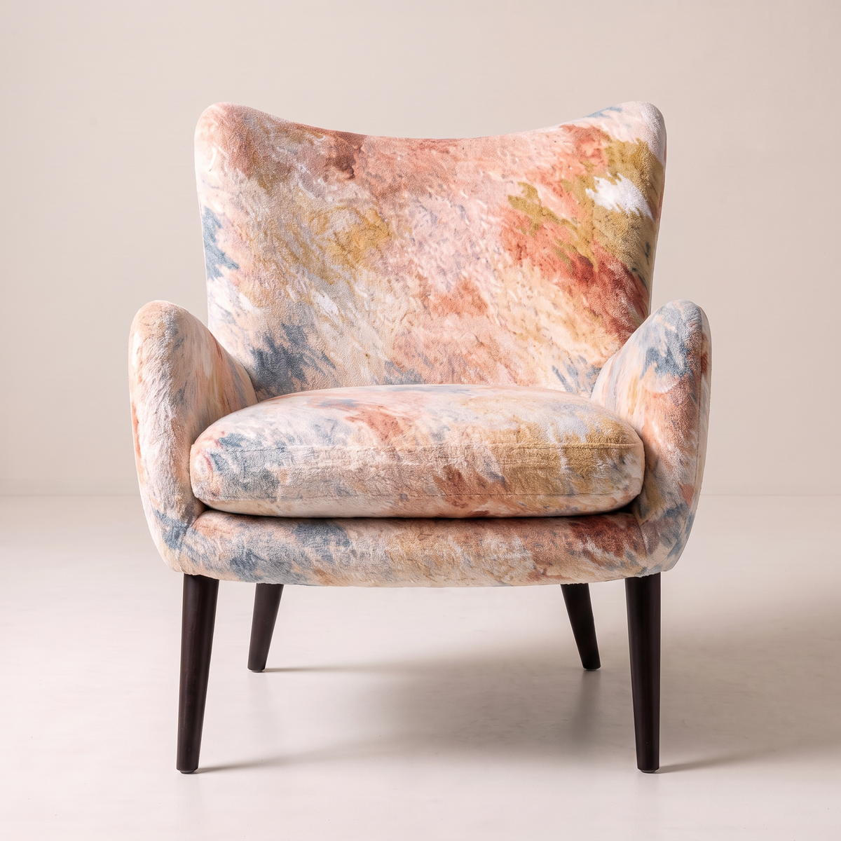 Canvas Fresco wingback lounge chair in painterly watercolour print with black tapered legs, front view