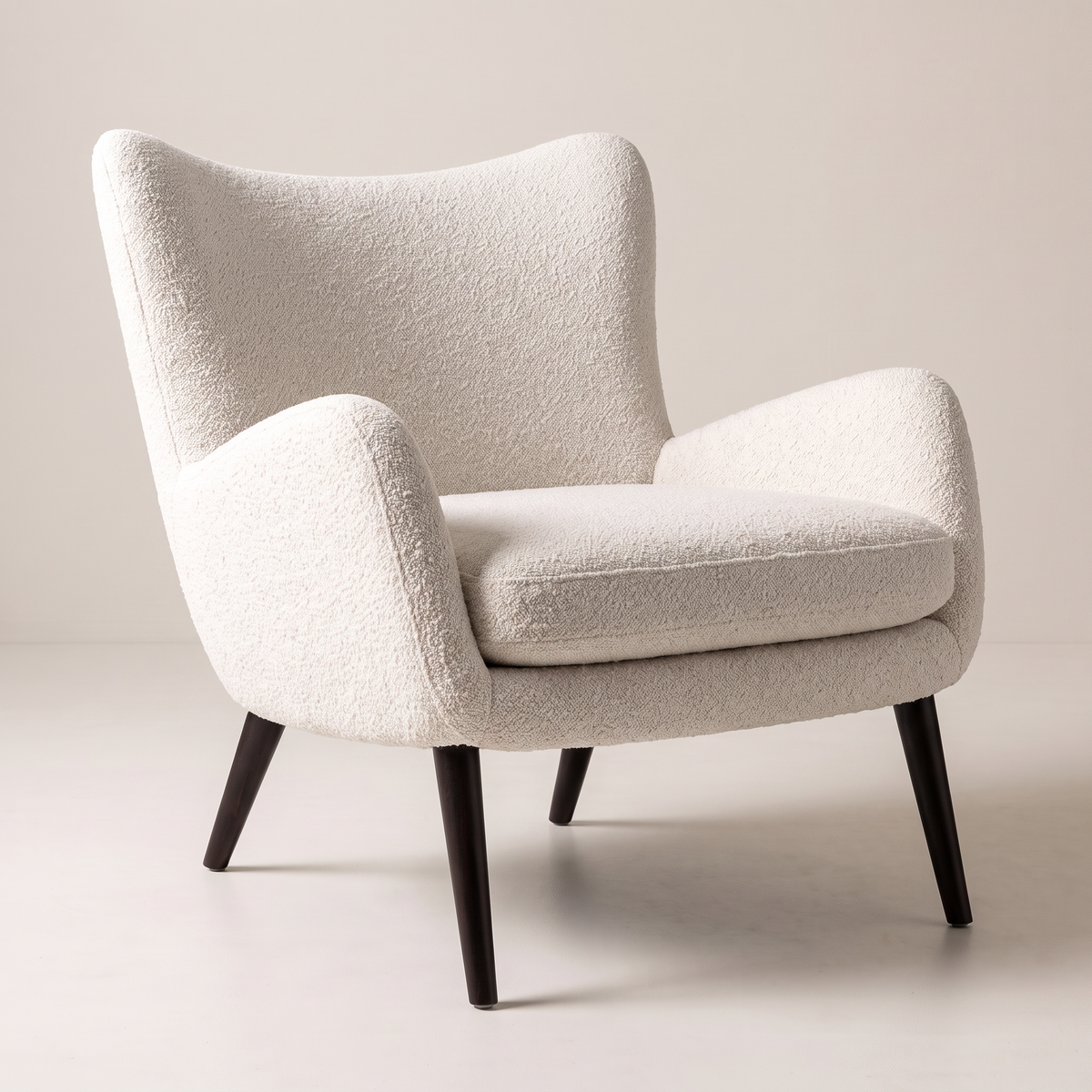Canvas Ivory lounge chair in ivory bouclé upholstery with dark tapered wood legs, front-right three-quarter view