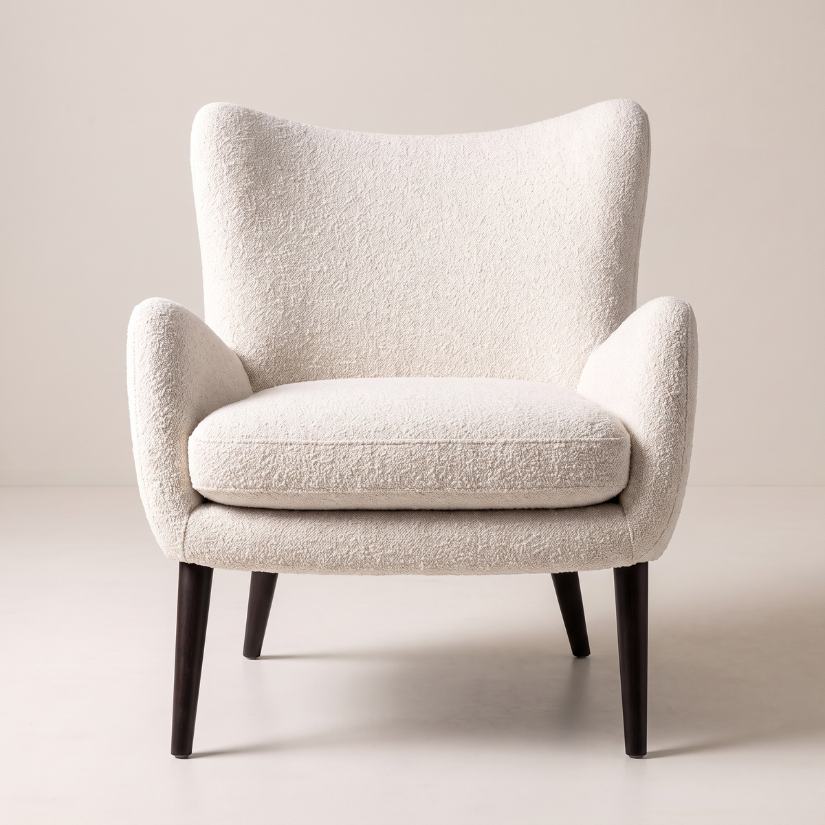 Canvas Ivory lounge chair in ivory bouclé upholstery with dark tapered wood legs, front view