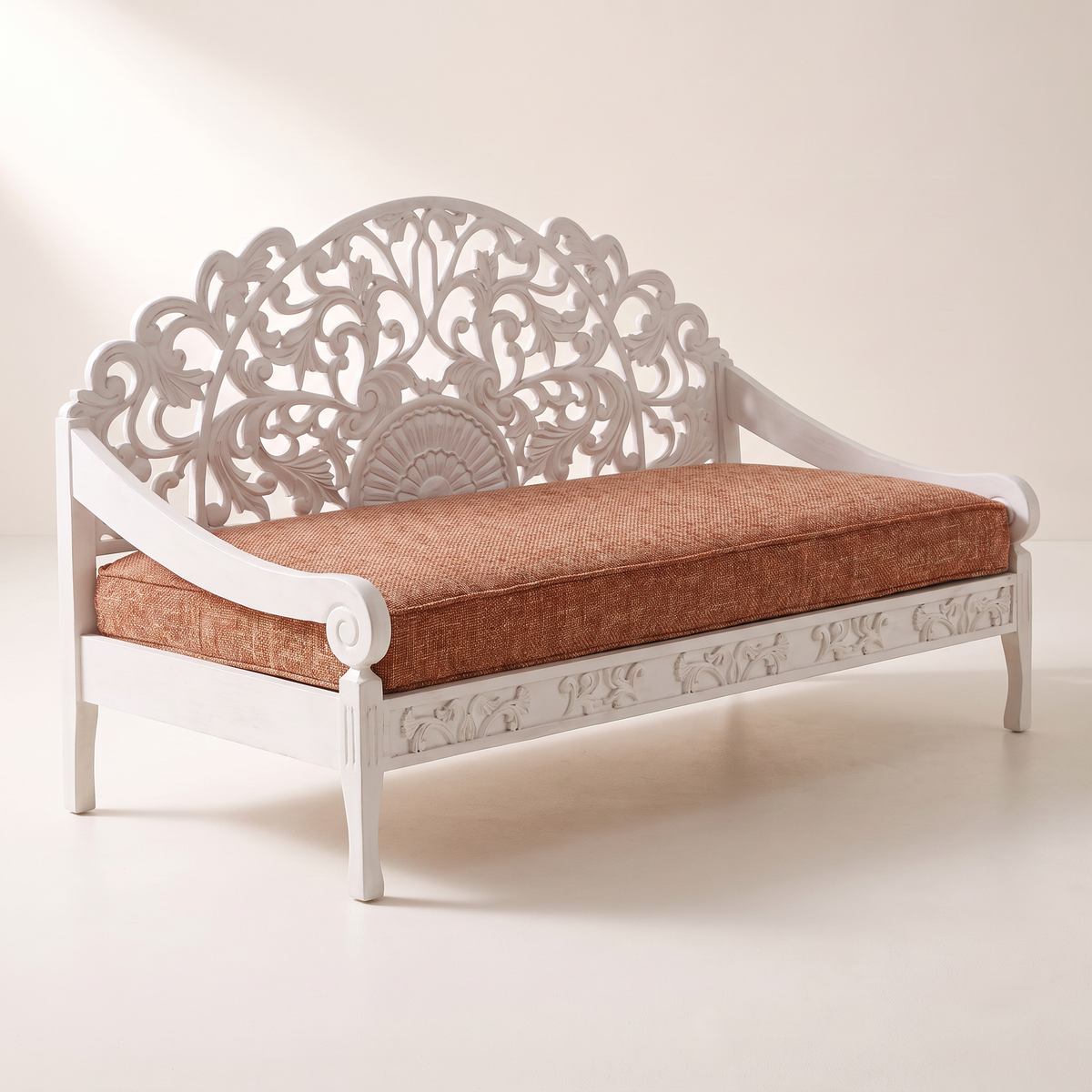 Carve White hand-carved white wooden sofa with openwork arched back and rust tweed seat cushion, front right three-quarter view