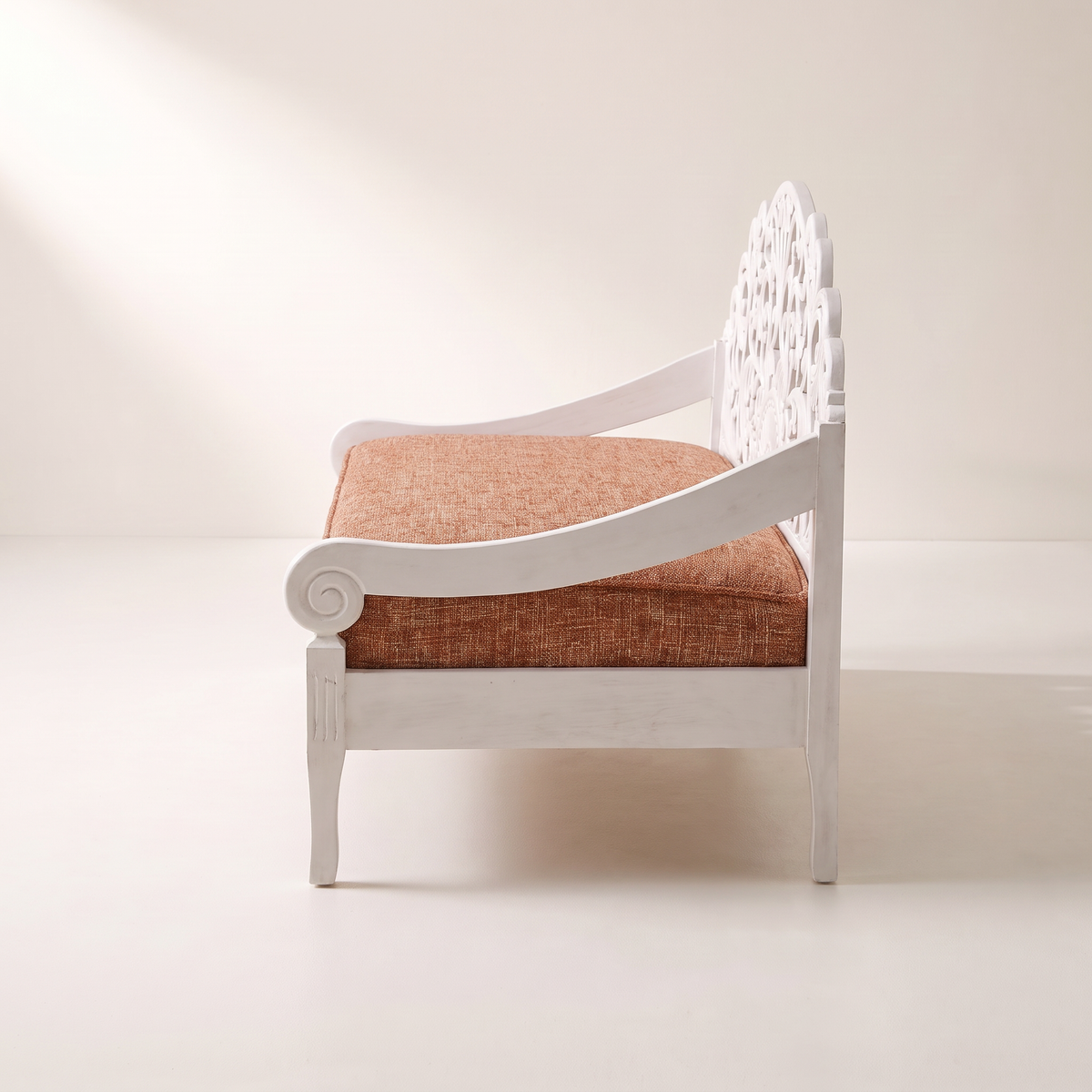 Carve White hand-carved white wooden sofa with scrolled open arm and rust tweed seat cushion, side profile view