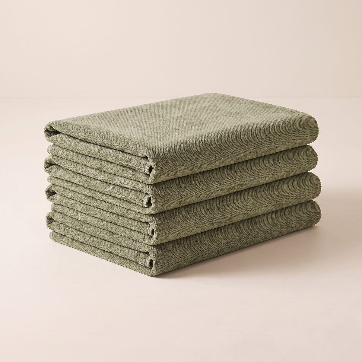 Chenille Sage upholstery fabric, neatly folded stack in muted sage green