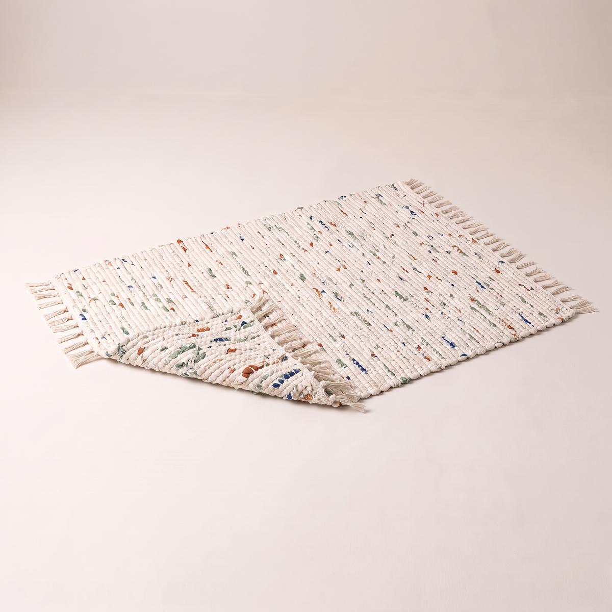 Chindi Rag Rug with a corner folded back to show the reversible rag weave