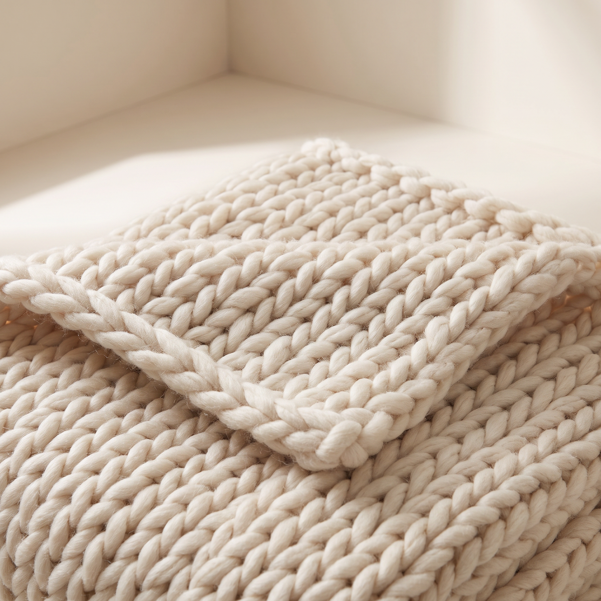 Chunky Knit Throw close-up of the oversized ivory stockinette stitches and edge