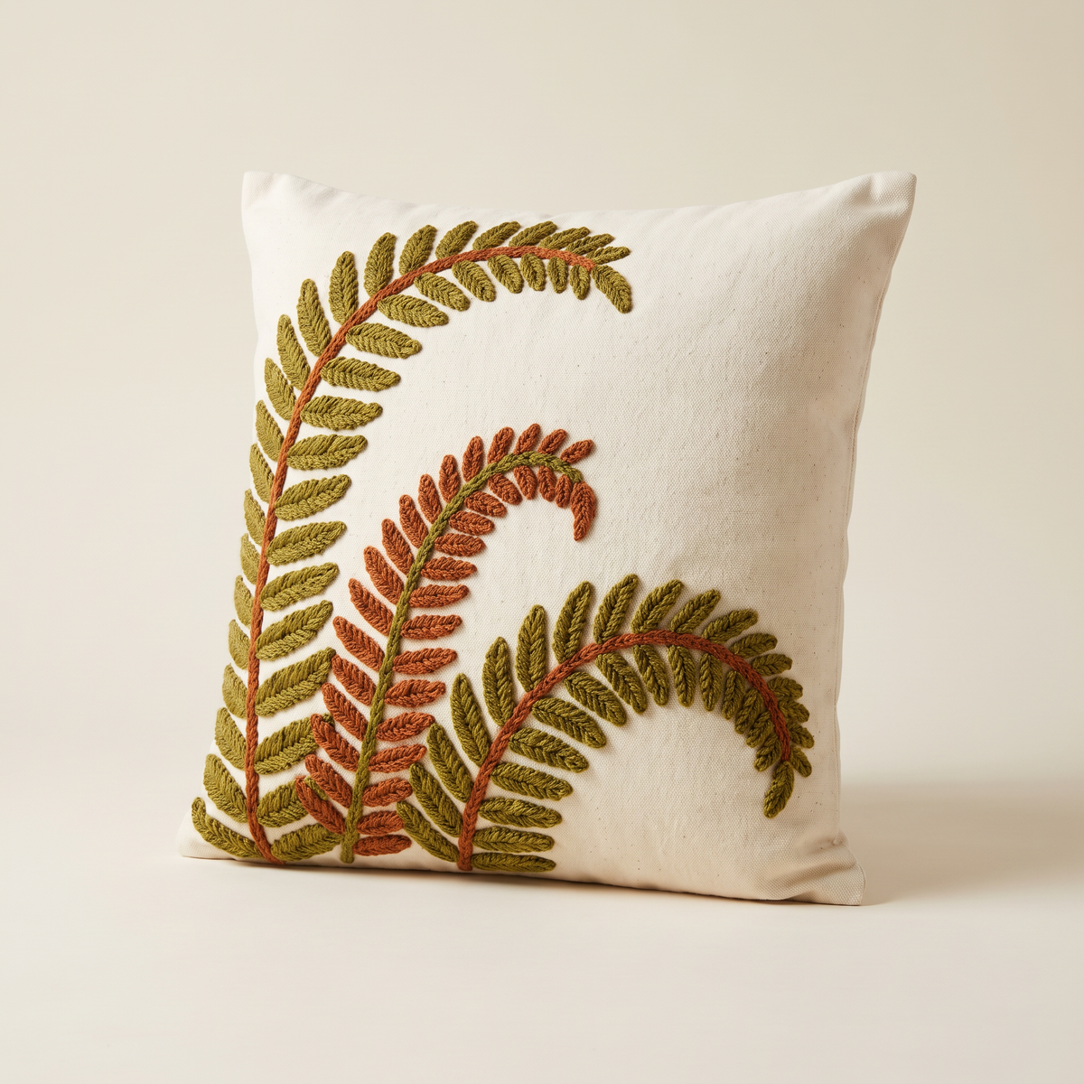 Crewel Fern Cushion in cream cotton with olive and rust wool crewel fern fronds, front three-quarter view
