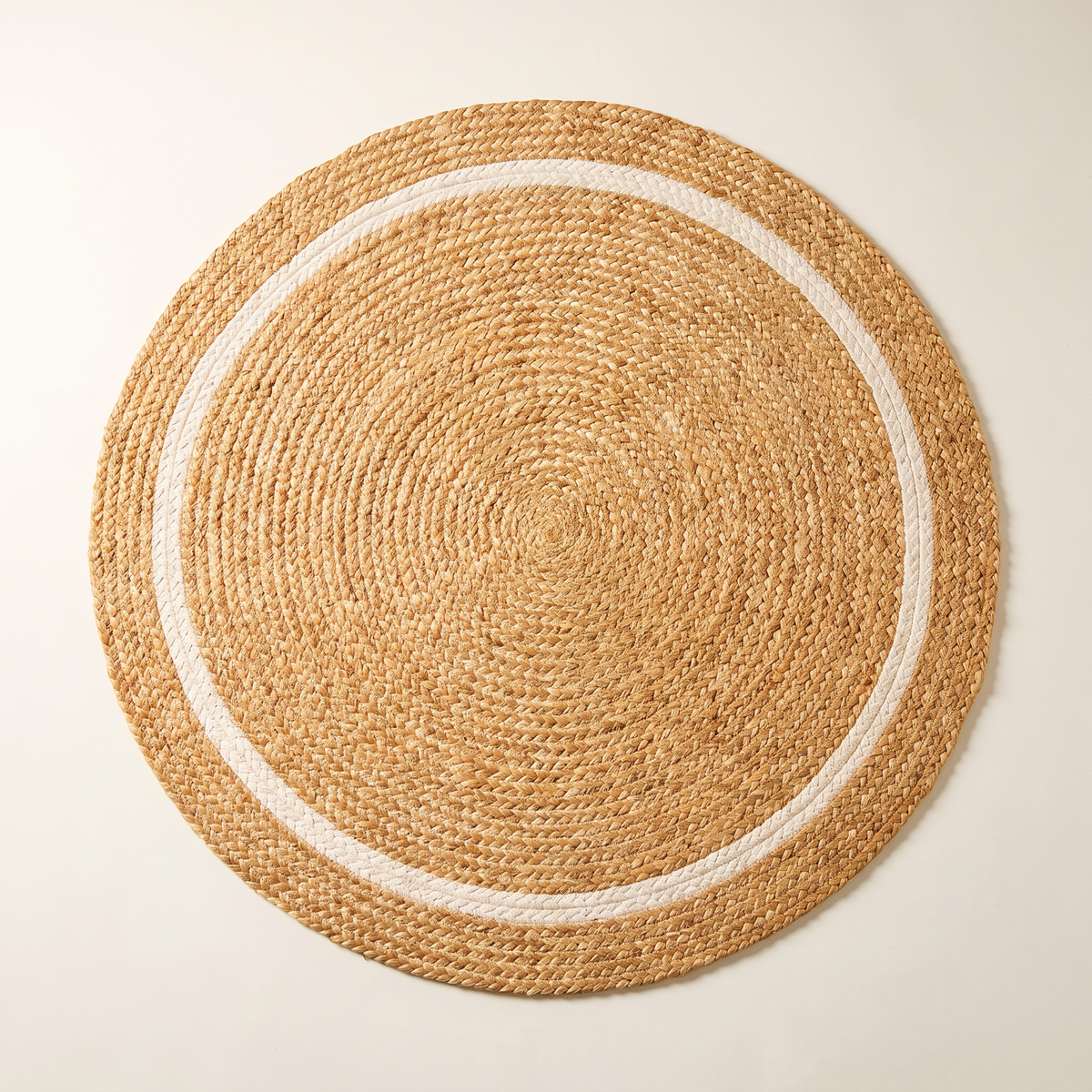Disc Jute Round braided jute rug, overhead flat lay showing the spiral and ivory ring