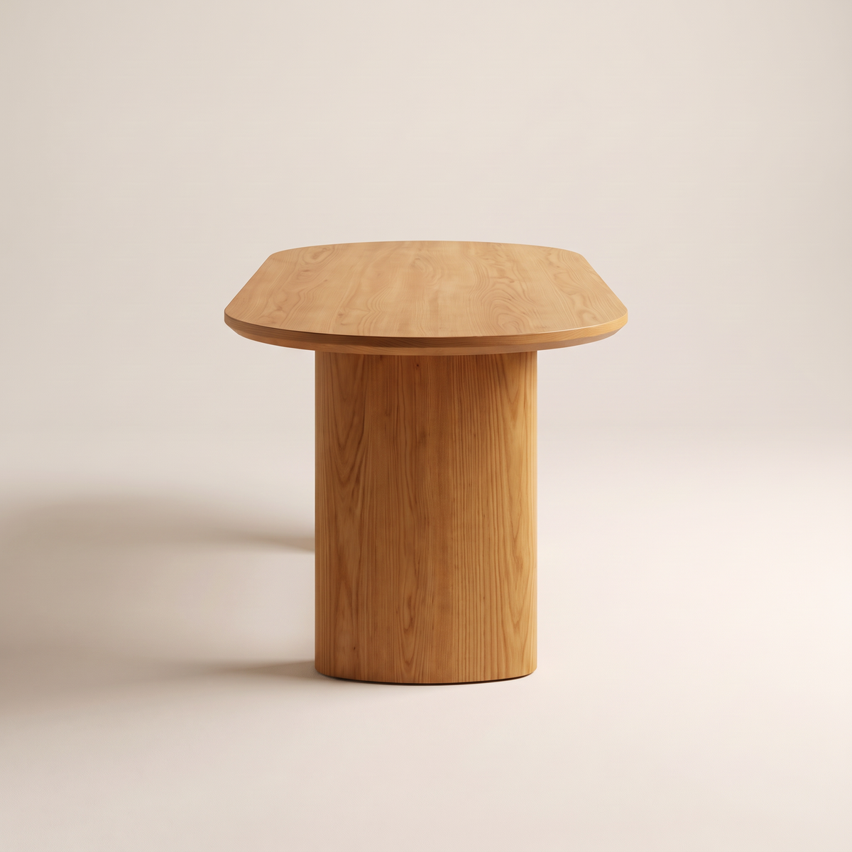 Ember Oval honey ash dining table seen from its rounded end, showing the oval pedestal