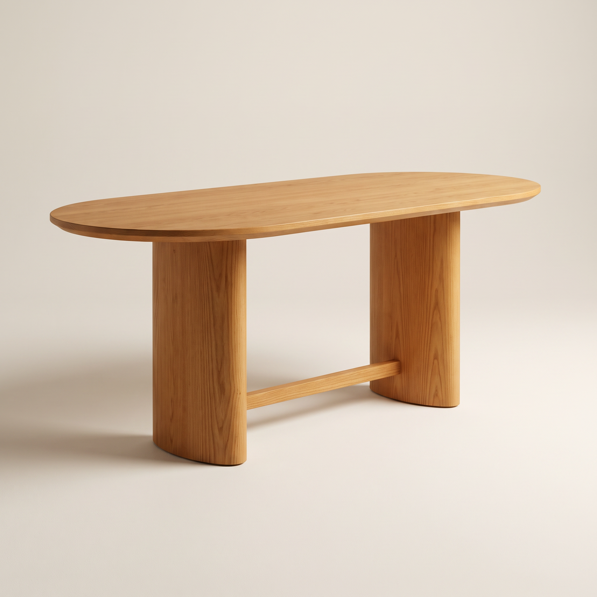 Ember Oval dining table in honey solid ash with racetrack-oval top and twin oval pedestals joined by a low stretcher, front three-quarter view