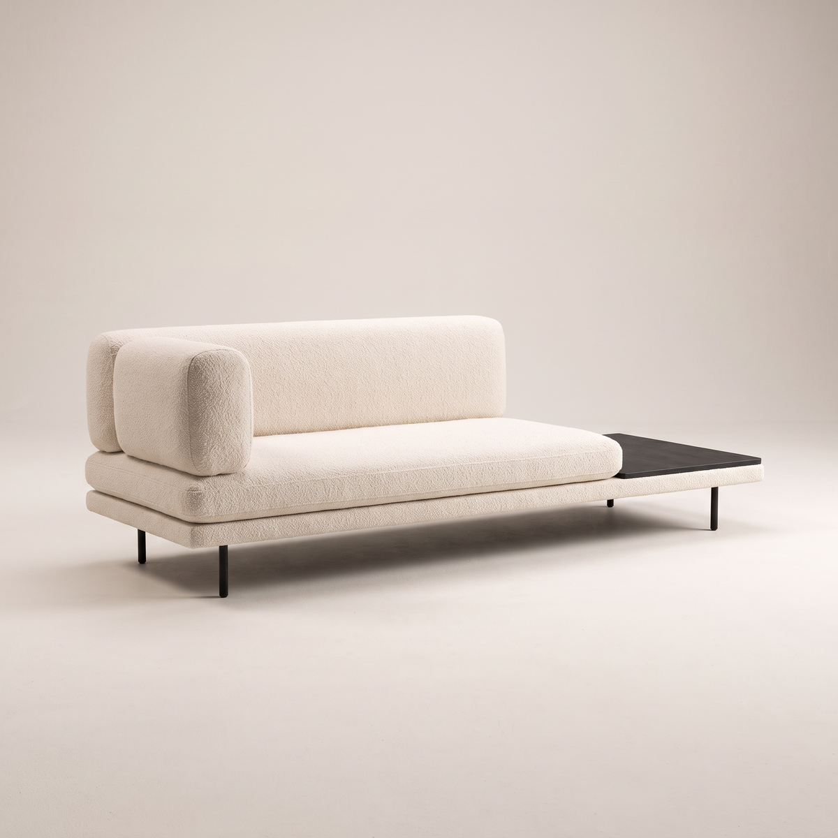 Eon Ivory low sofa in ivory boucle-style upholstery with dark table panel and slim black legs, three-quarter view