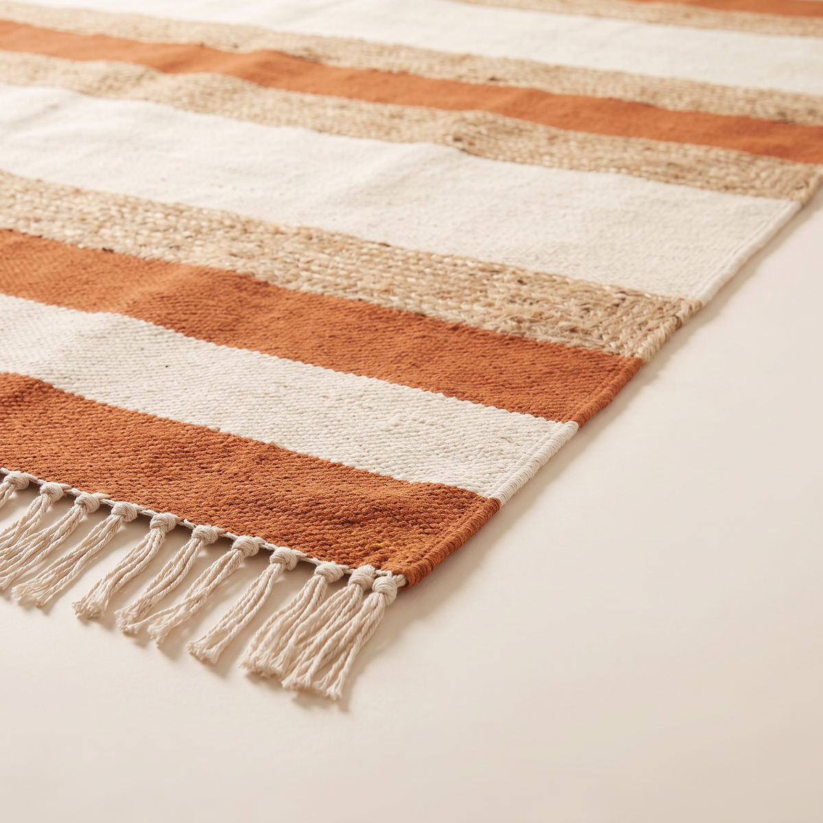 Ganga Stripe Dhurrie corner close-up showing cotton and jute flat weave and knotted fringe