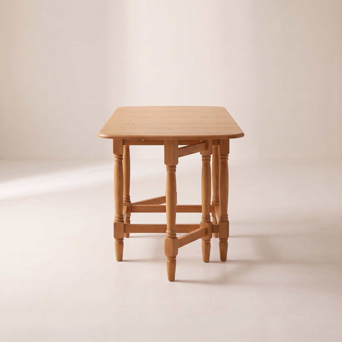 Gateleg Compact drop-leaf table seen from its end, showing a raised leaf on its swing-out gate leg