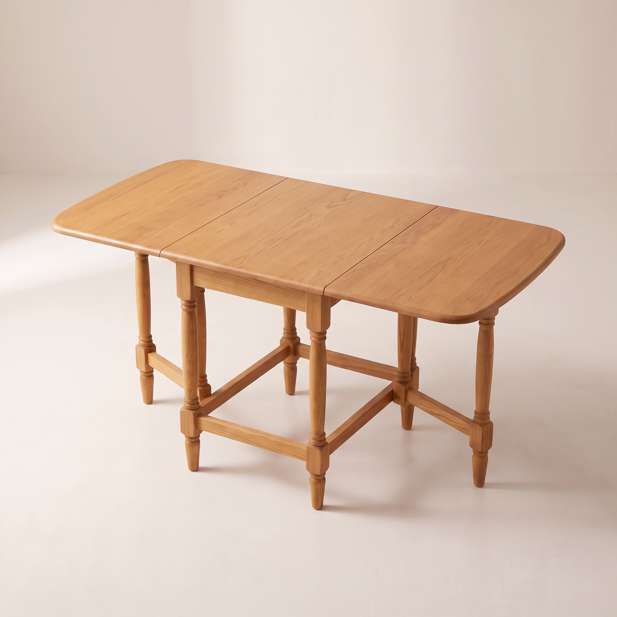 Gateleg Compact drop-leaf table showing its open ash top with two leaf seams and the gate-leg structure, elevated three-quarter view