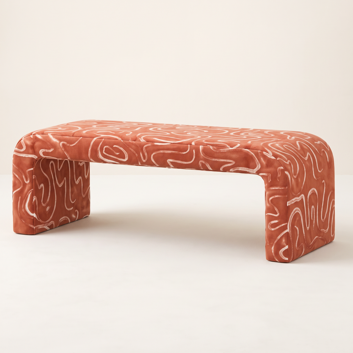 Glyph – Line waterfall bench in terracotta fabric with cream squiggle-line print, front three-quarter view