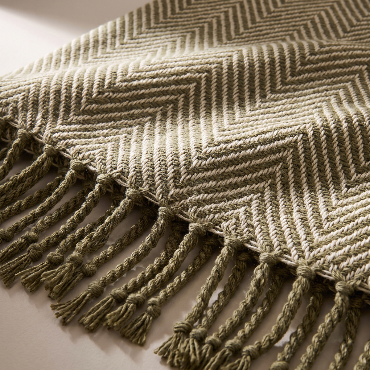 Herringbone Fringe Throw close-up of the olive and cream herringbone weave and twisted fringe
