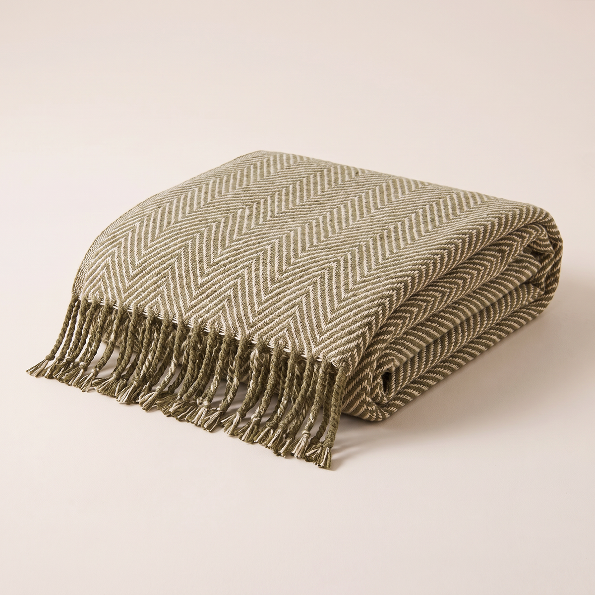Herringbone Fringe Throw in olive and cream, folded neatly with twisted fringe showing