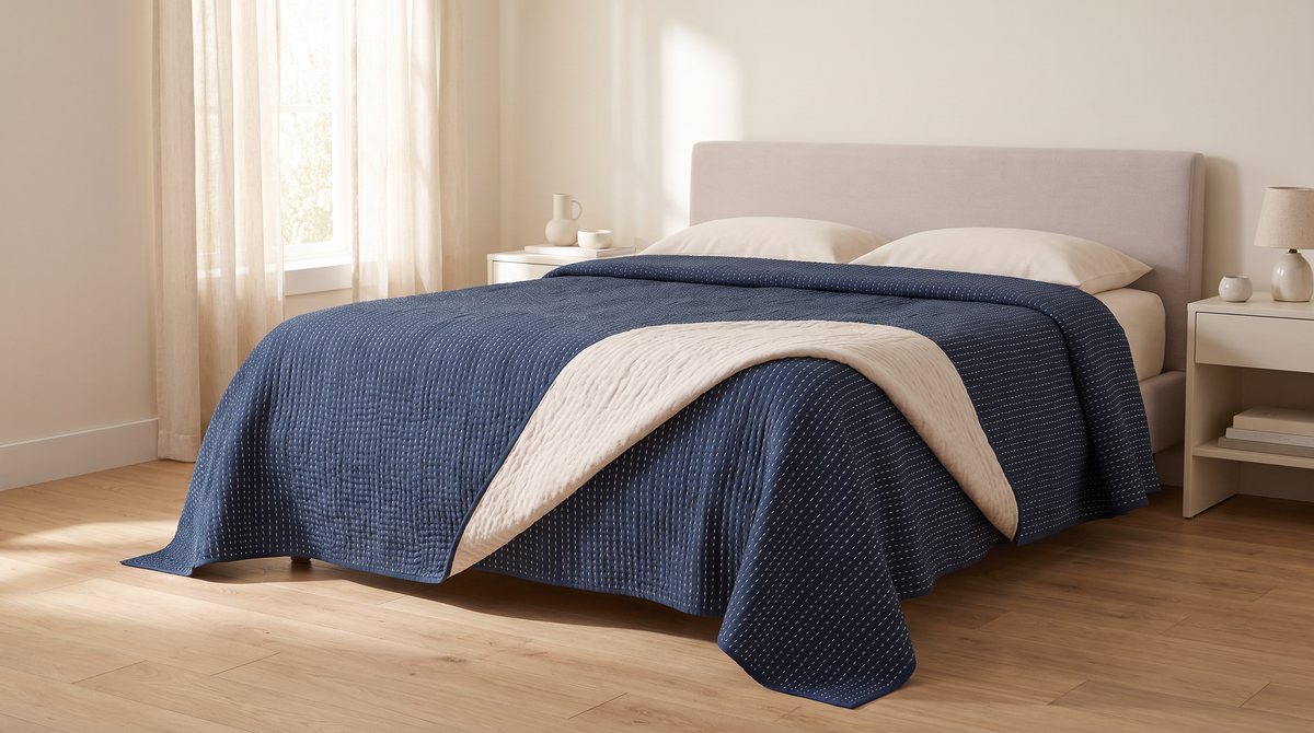 Kantha Quilted Coverlet in indigo styled on a bed in a calm bedroom