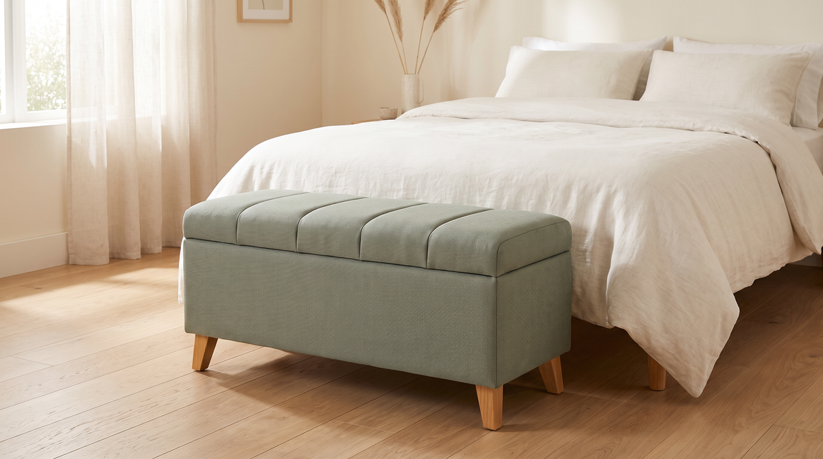 Keel Storage Bench in sage fabric styled at the foot of a bed in a calm bedroom