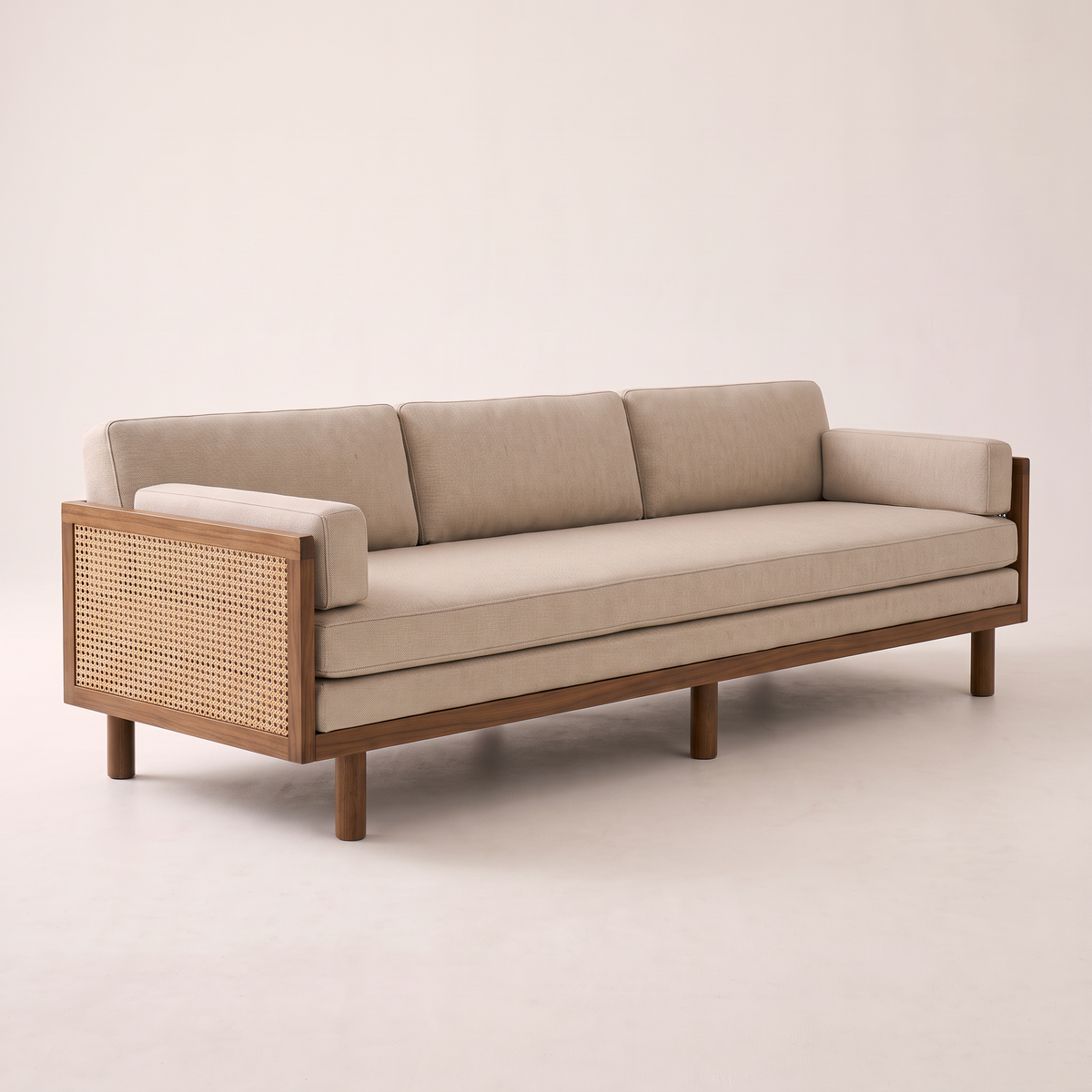 Kora Cane sofa with wooden frame, cane arm panels and oatmeal upholstery, front right three-quarter view