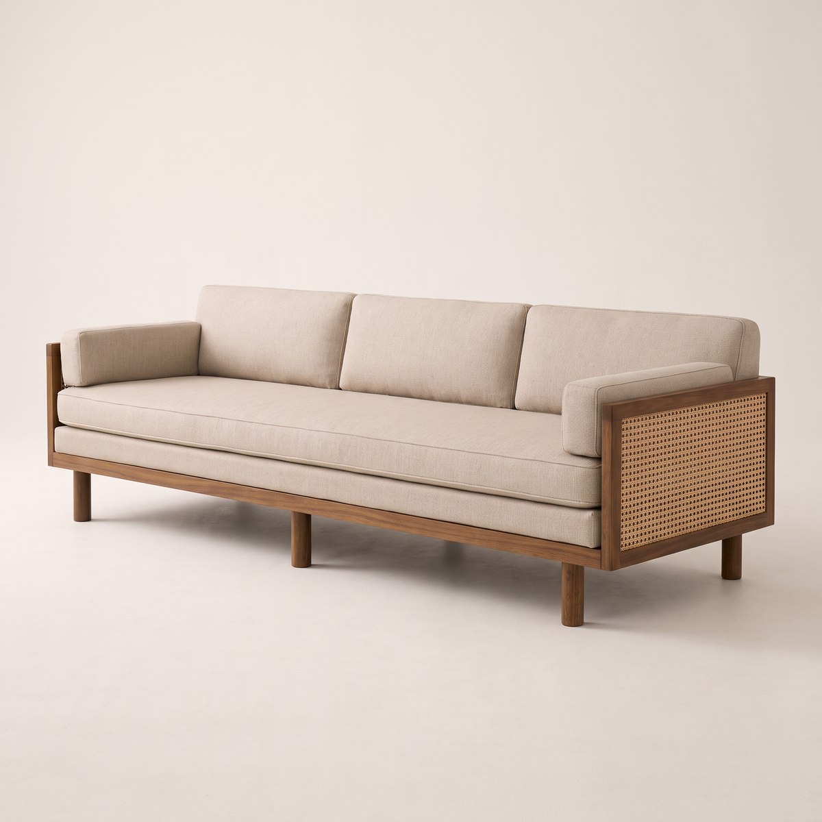 Kora Cane sofa with wooden frame, cane arm panels and oatmeal upholstery, front three-quarter view