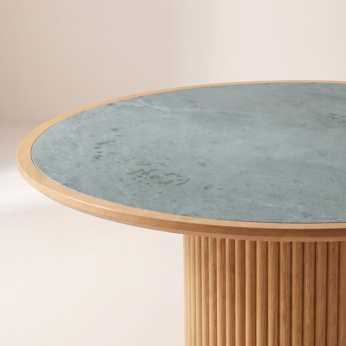 Kota Round dining table close-up of the honed Kota stone top, honey ash rim and fluted ash drum