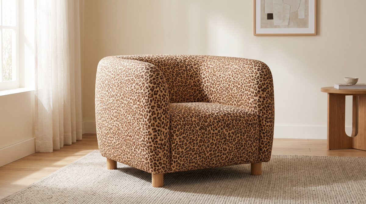 Leopard Jacquard fabric shown as the upholstery of a rounded accent armchair in a calm living room