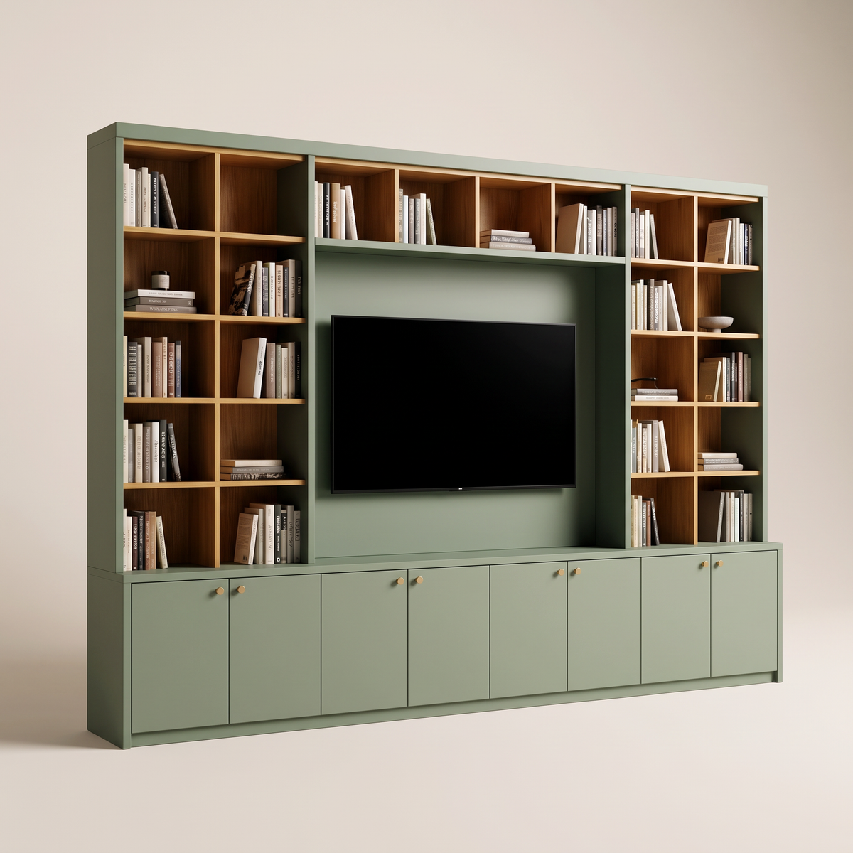 Library Frame TV wall bookcase in matte sage green with honey ash shelves framing the TV and closed sage cabinets with brass knobs below, three-quarter view