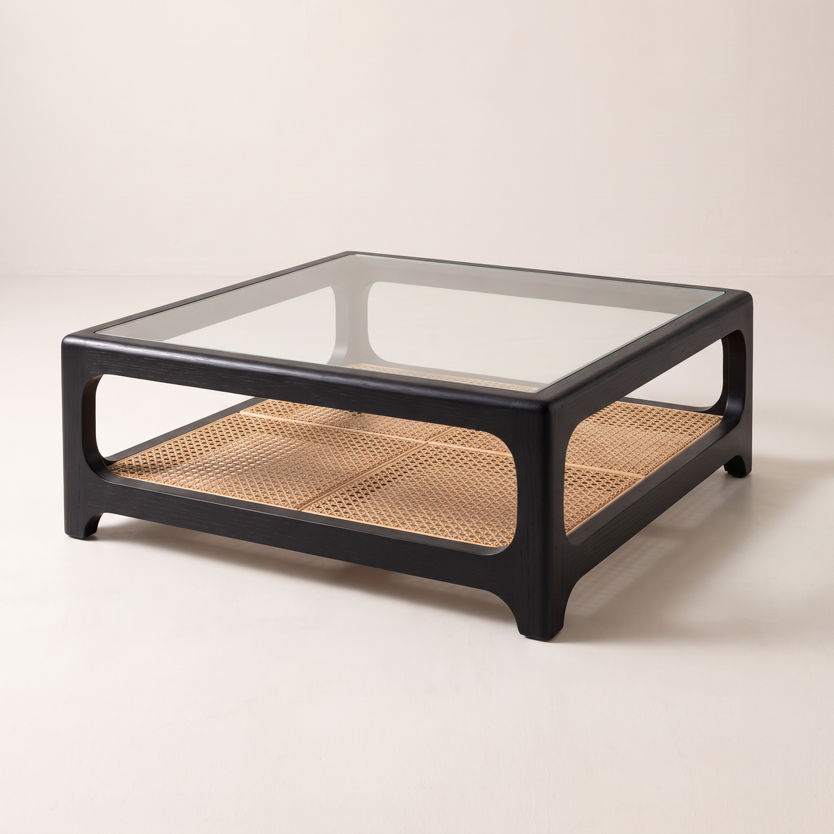 Linea Cane Black coffee table with black ash frame, clear glass top and natural cane shelf, front right three-quarter view