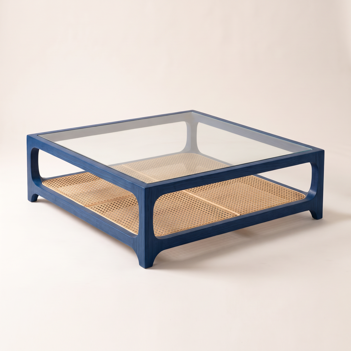 Linea Cane Blue coffee table with blue-stained ash frame, clear glass top and natural cane shelf, front right three-quarter view