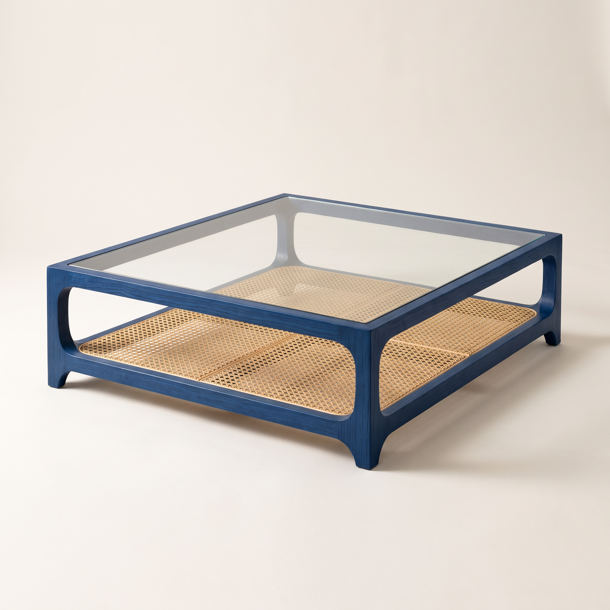 Linea Cane Blue coffee table with blue-stained ash frame, clear glass top and natural cane shelf, front three-quarter view