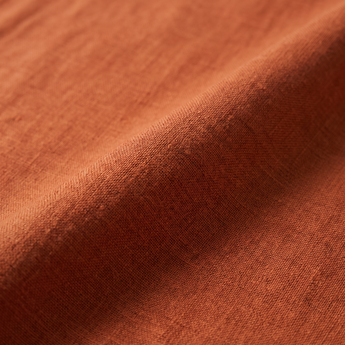 Linen Rust upholstery fabric, close-up of the matte linen weave and slubs
