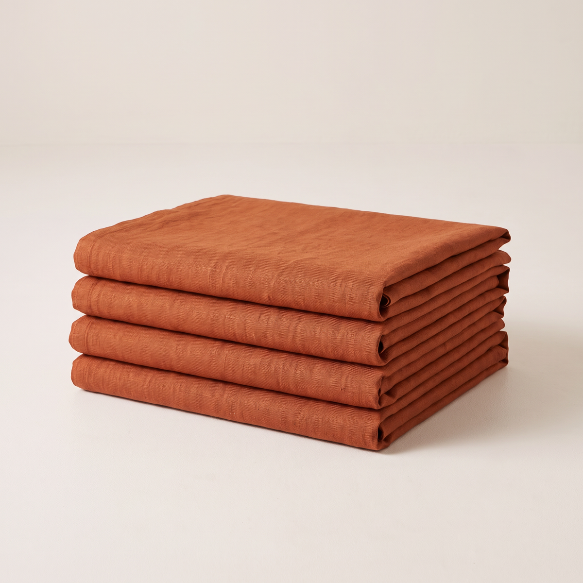 Linen Rust upholstery fabric, neatly folded stack in rust orange