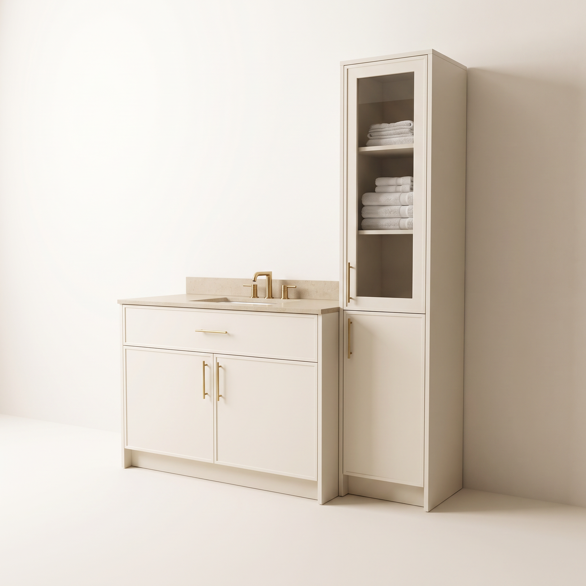 Linen Tower Vanity in matte ivory with drawer and two doors, brass bar pulls, beige quartz top and basin, beside a tall tower with glass upper door showing folded towels, three-quarter studio view