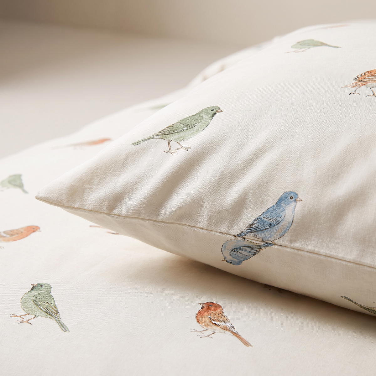 Close-up of Little Flock pillow cover and duvet showing the illustrated sparrows and finches