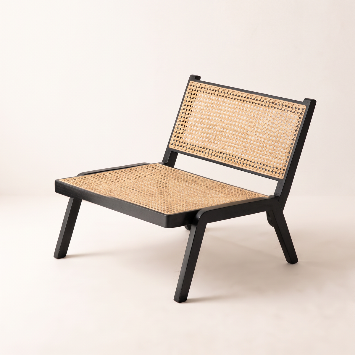 Loom Black lounge chair in black solid-wood frame with natural cane seat and back, front three-quarter view