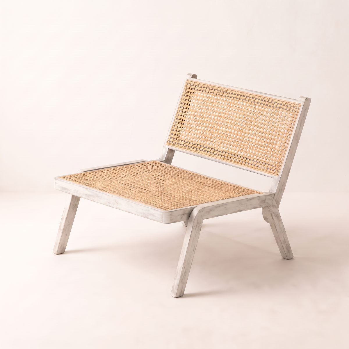 Loom White lounge chair in whitewashed solid-wood frame with natural cane seat and back, front three-quarter view