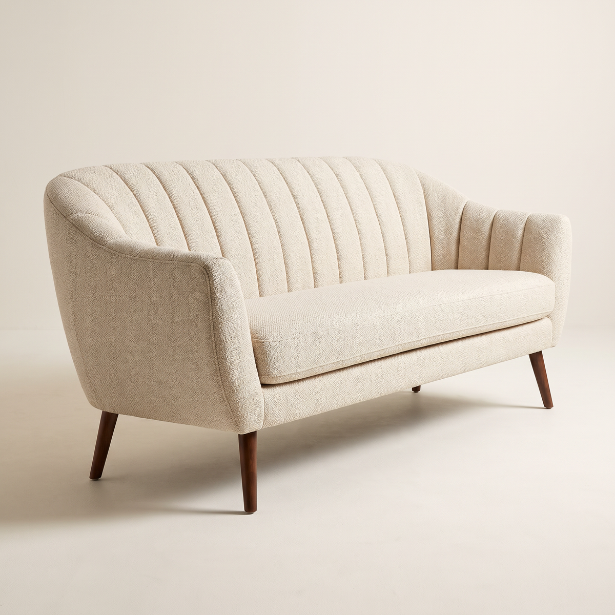 Luna Ivory sofa in ivory channel-tufted upholstery with dark tapered wooden legs, front right three-quarter view