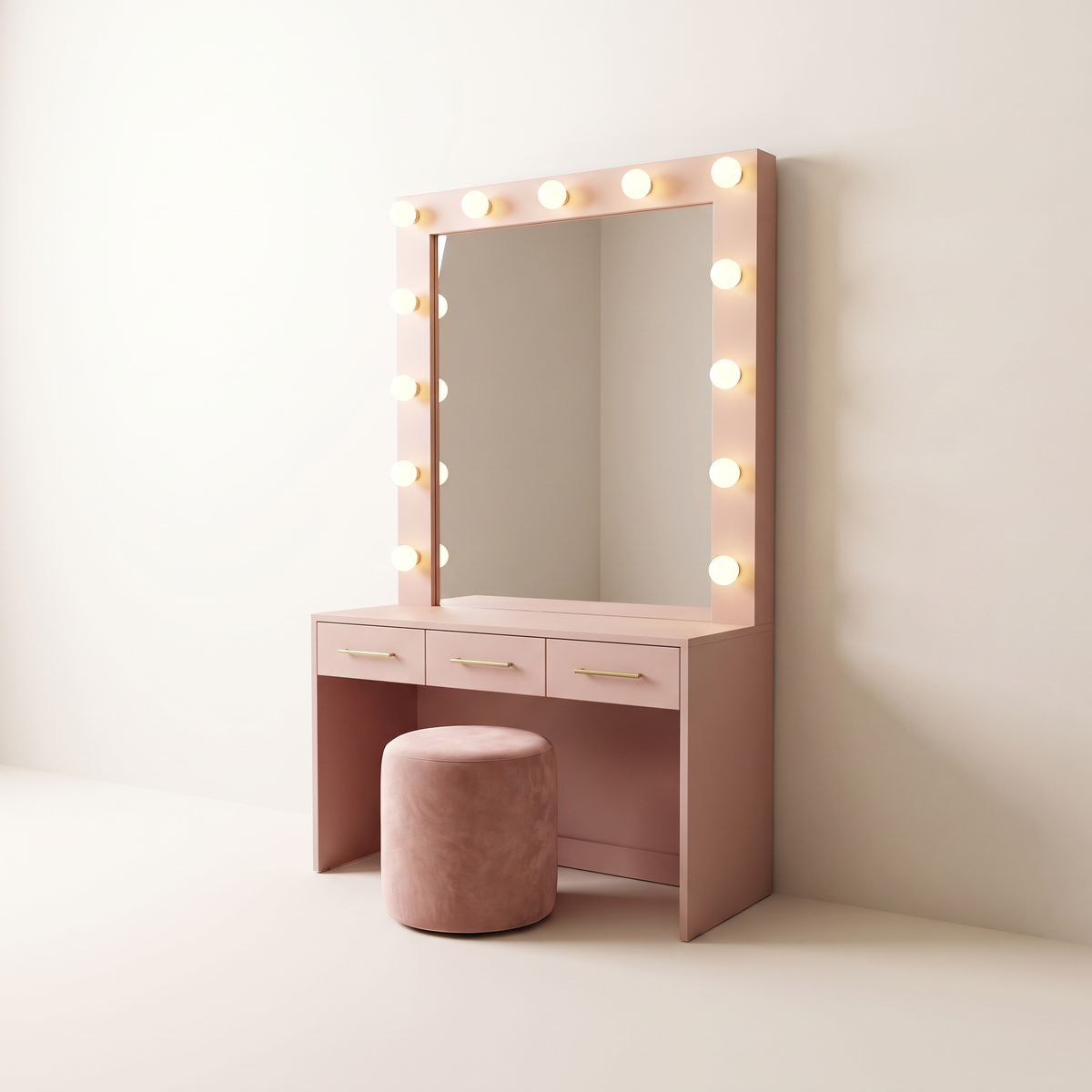 Marquee Dressing Unit in matte blush pink with three brass-pull drawers, tall mirror framed by warm globe bulbs on three sides and a blush velvet stool, three-quarter studio view