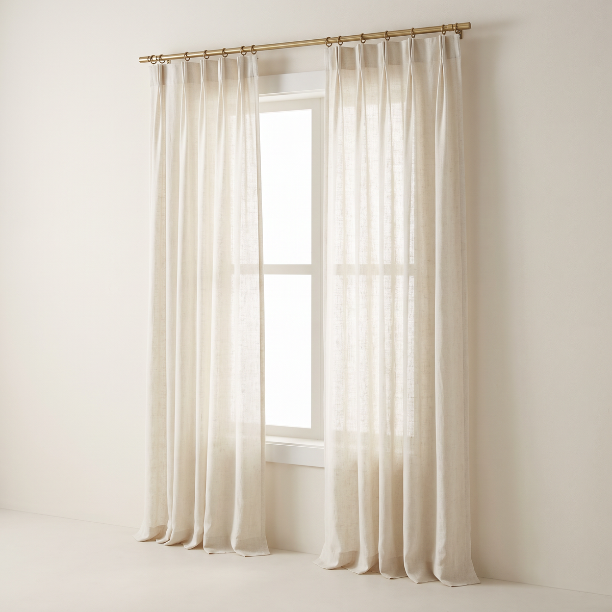 Mist Linen Sheer curtains in ivory linen-blend voile with triple pinch pleats on a brass rod, front three-quarter view