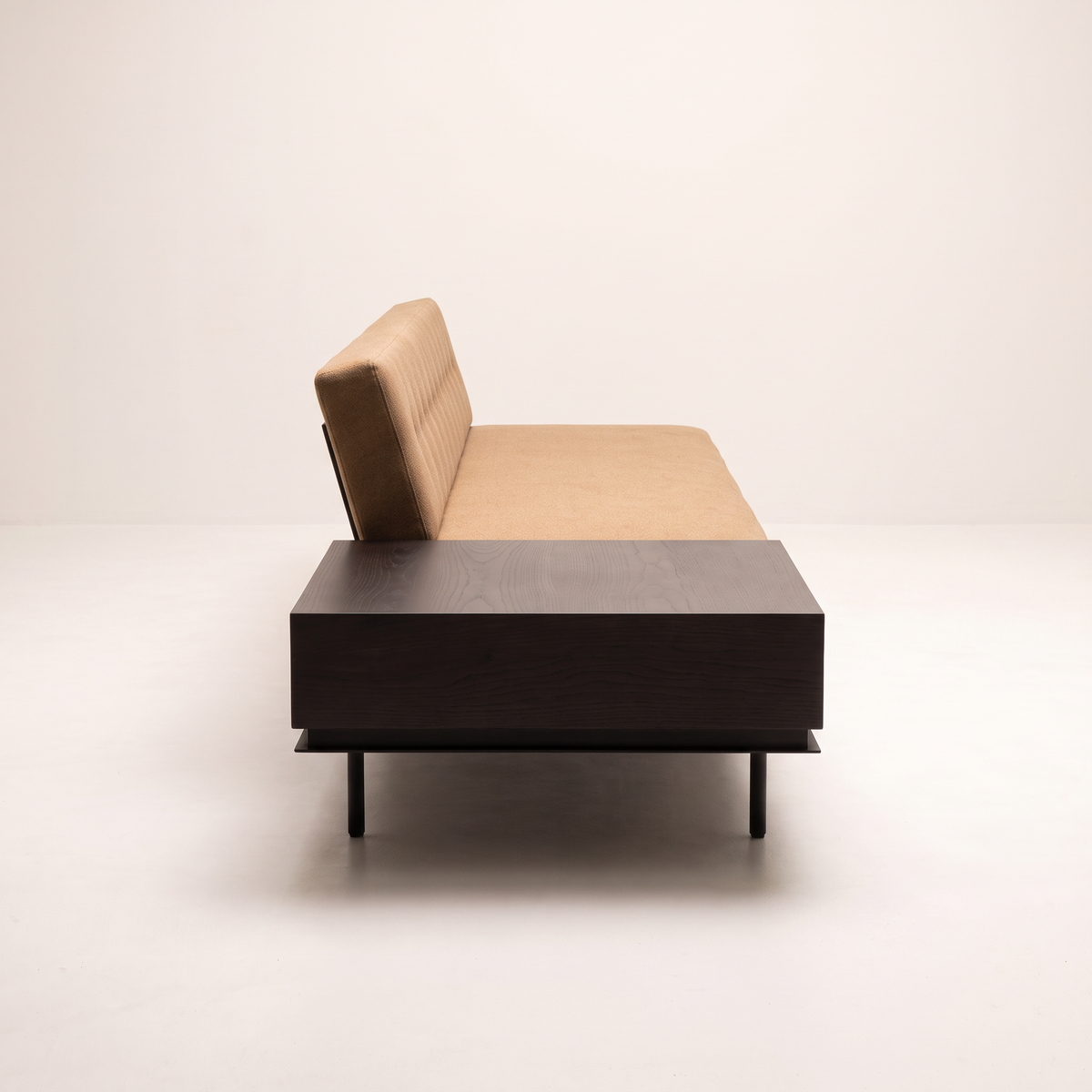 Monolith Brown sofa with dark wood table end, side profile view