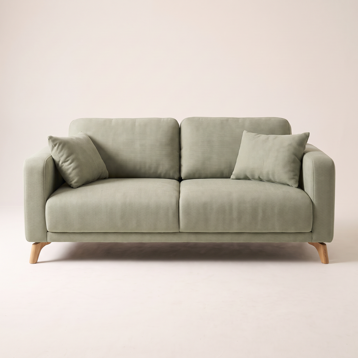 Nest Sage sofa in sage green upholstery with angled wooden legs, front view