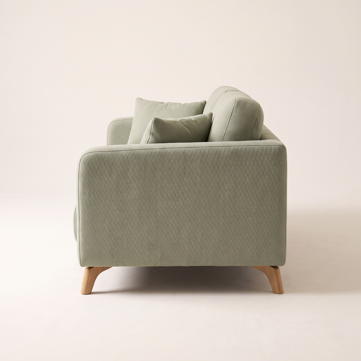 Nest Sage sofa in sage green upholstery with angled wooden legs, side profile view