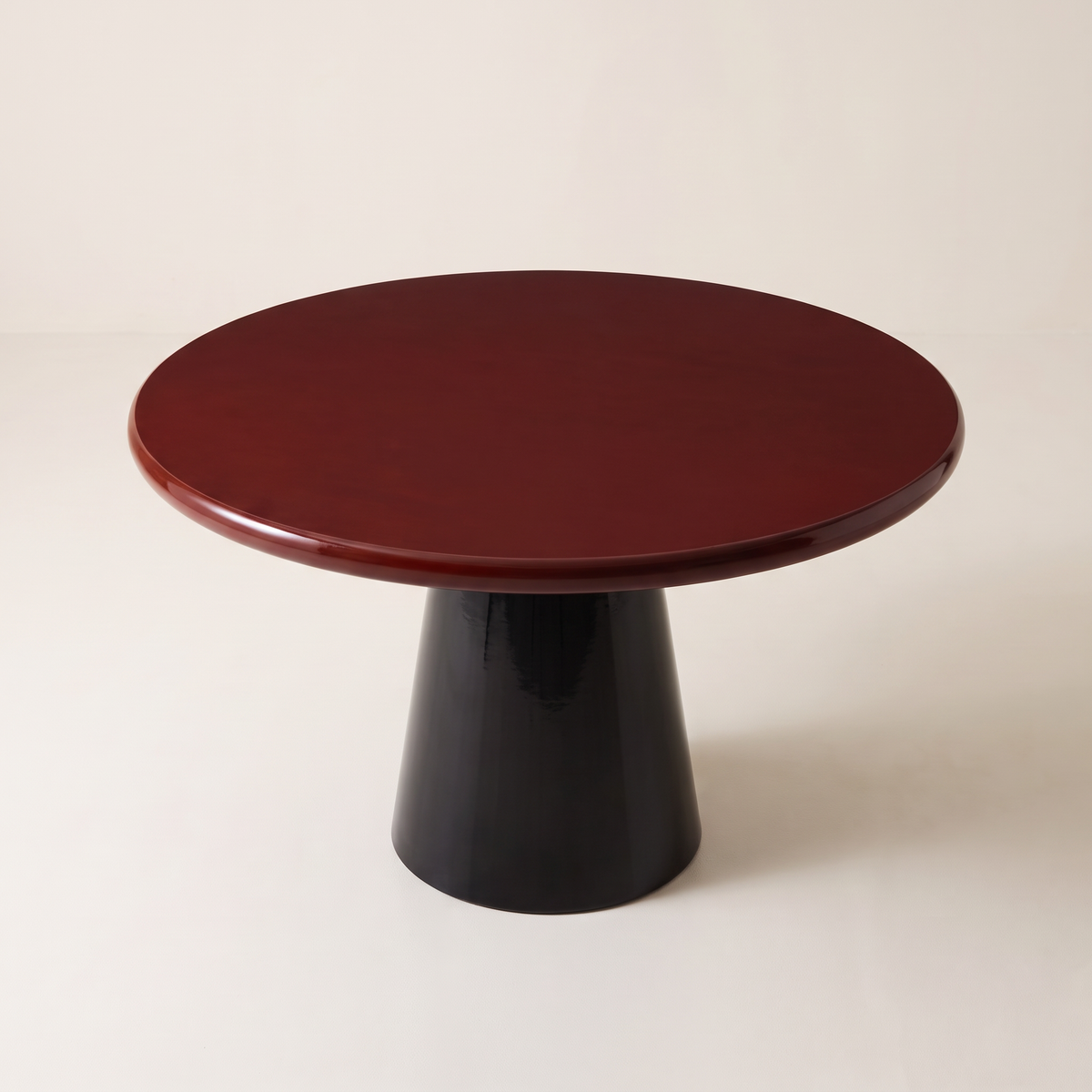 Obel round dining table with burgundy gloss top on a black conical pedestal base, elevated three-quarter view
